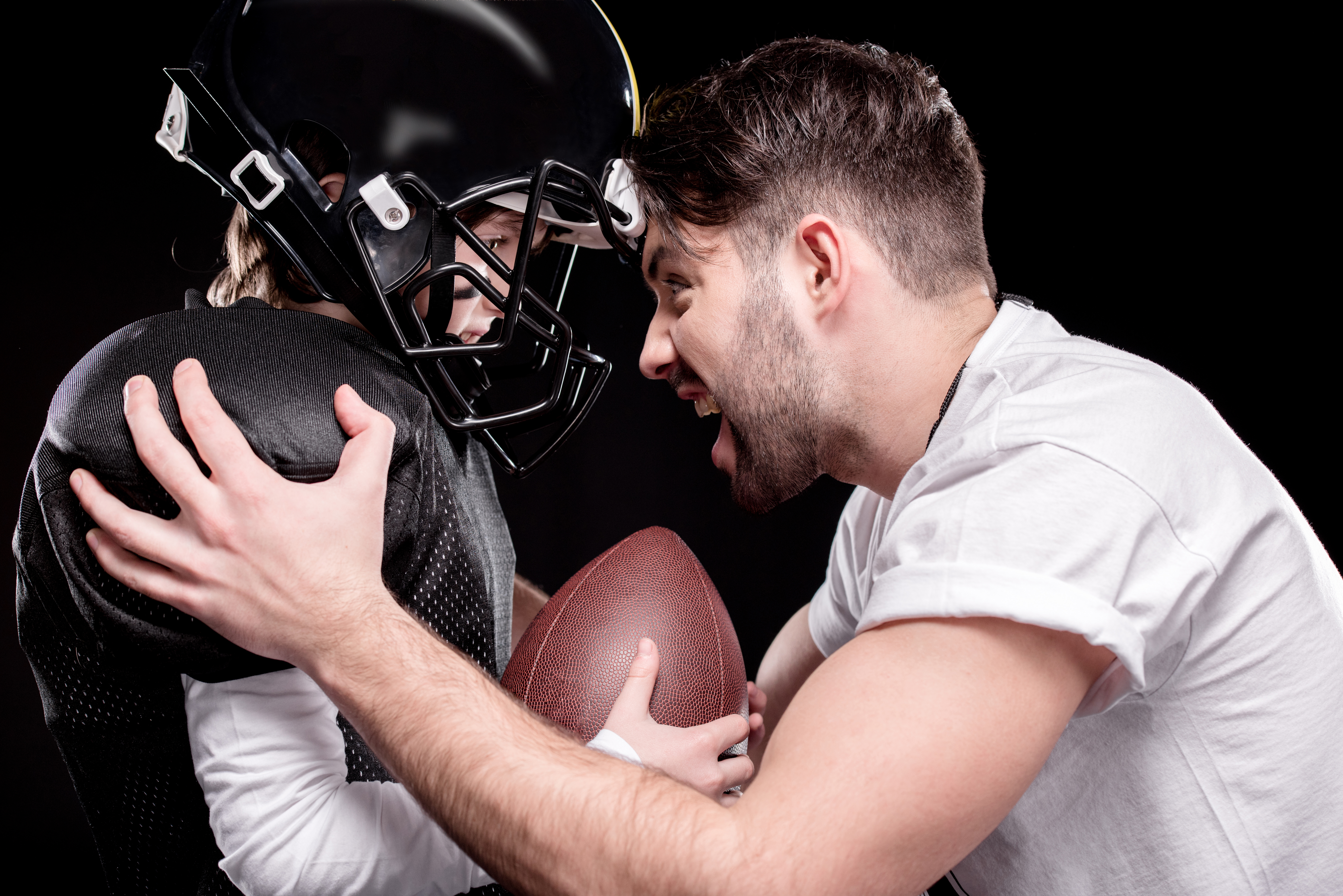 Image of a football coach motivating a player - shows that Hiring a coach will push away from your confot zone e help improve your self-worth